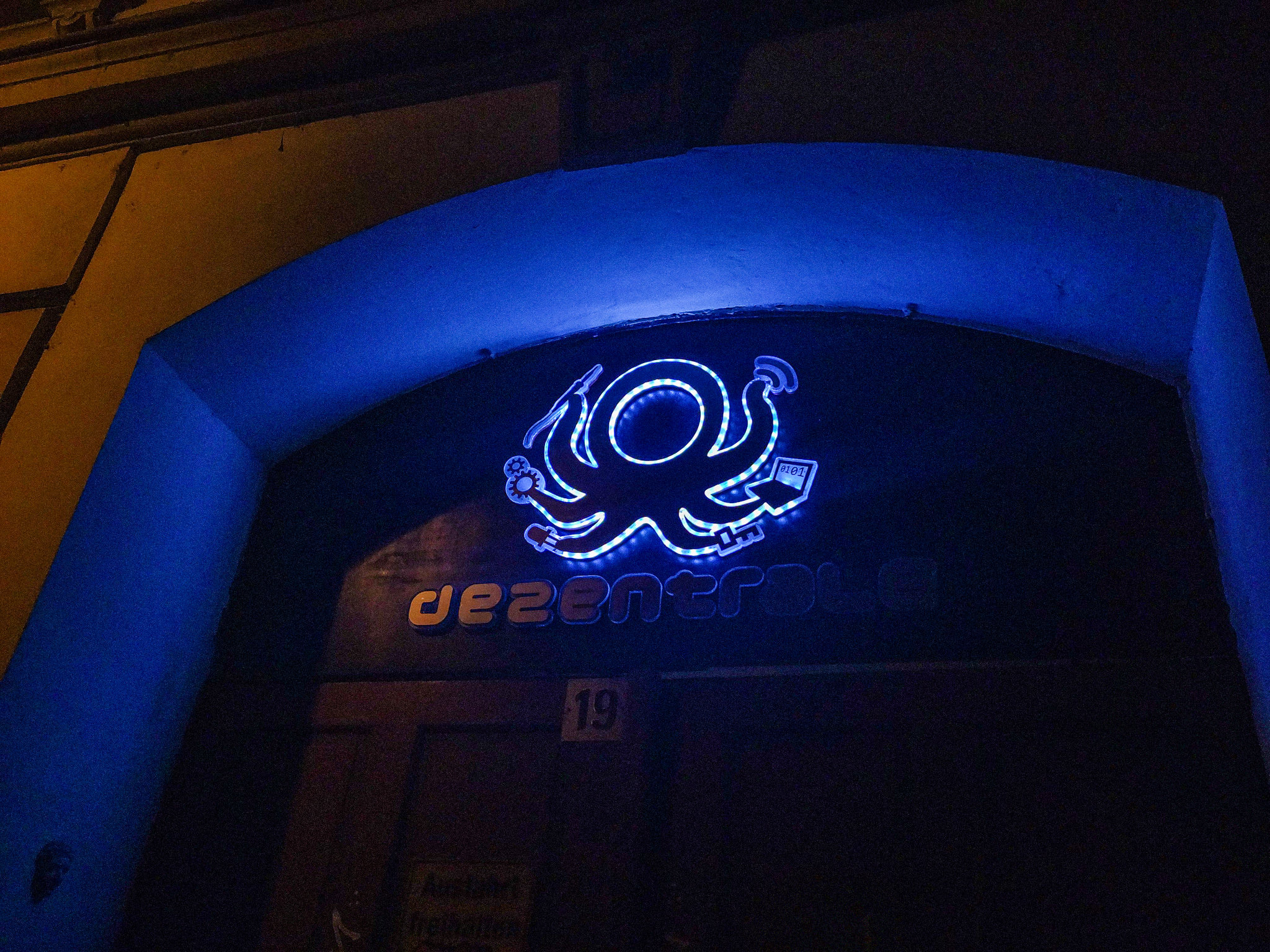 Das Logo der dezentrale an der Eingangstür. Es wird mit RGB LEDs weiß beleuchtet. Der Schriftzug ist unbeleuchtet